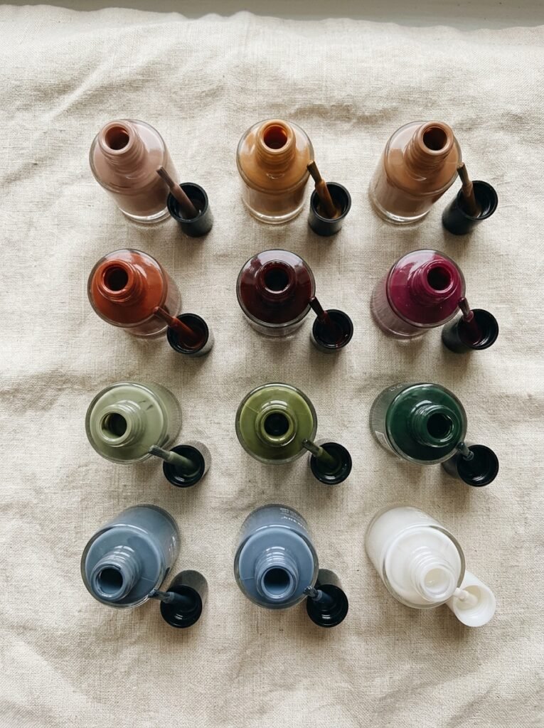 Fall nail polish bottles in brown, wine, olive and slate arranged on linen