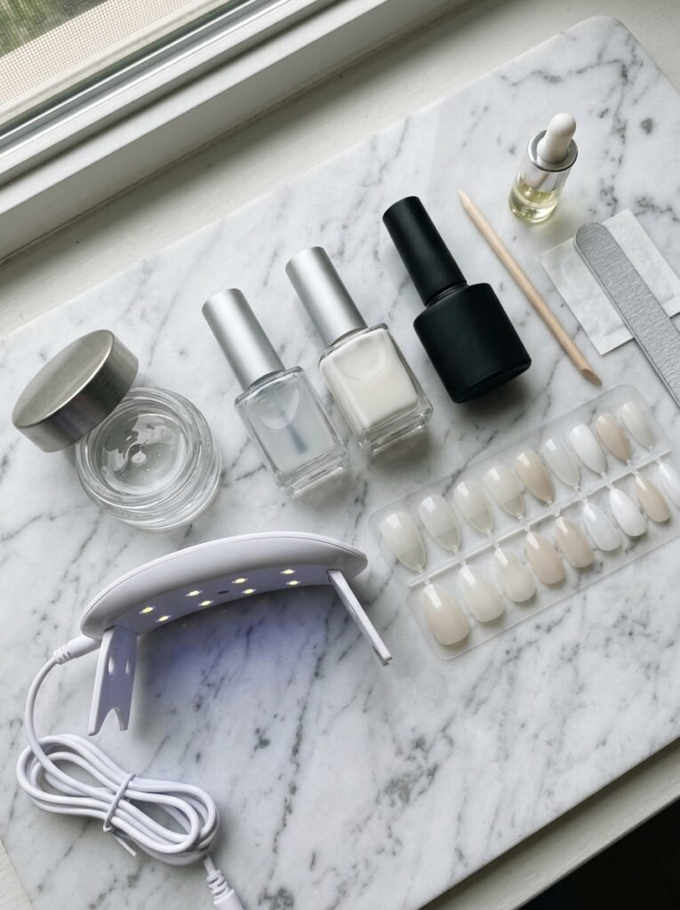 Sheer white polish, gel polish, a lamp, builder gel, and press ons on a marble surface